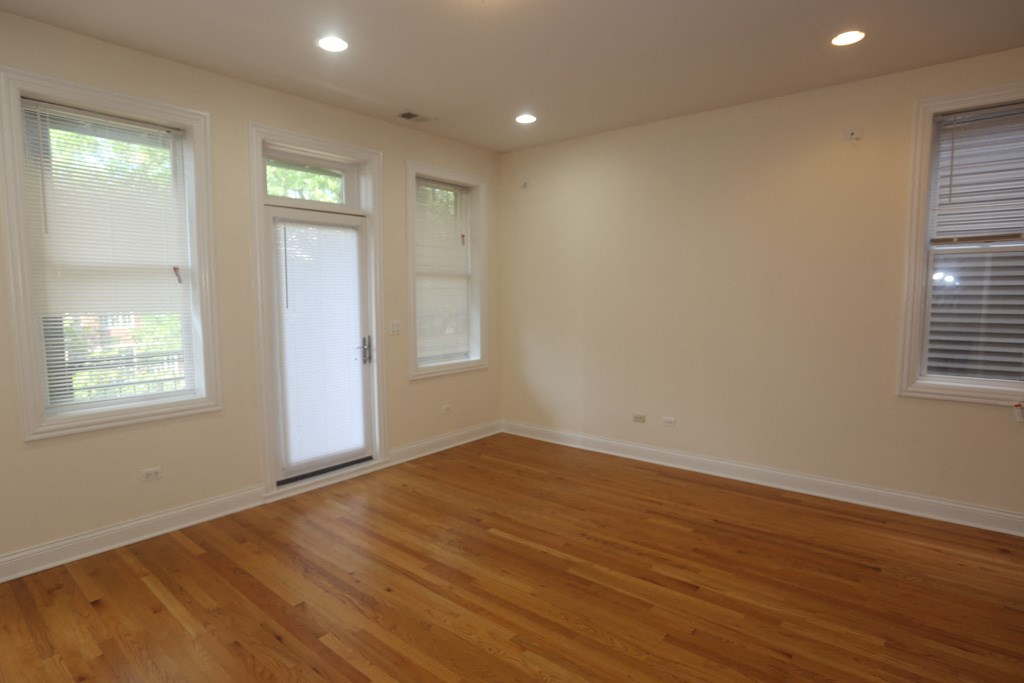 a living room with wood floors and a door and windows