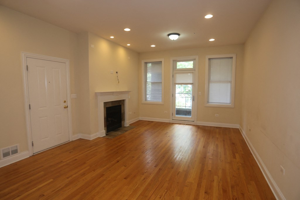 a living room with a fireplace and a wooden floor