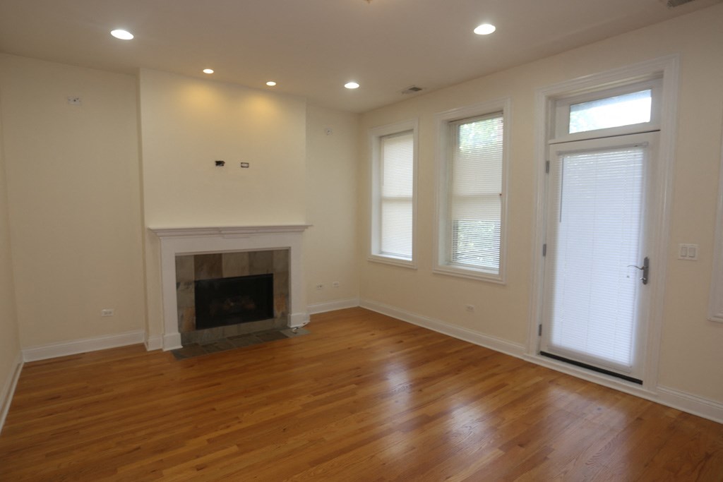 a living room with a fireplace and a wooden floor