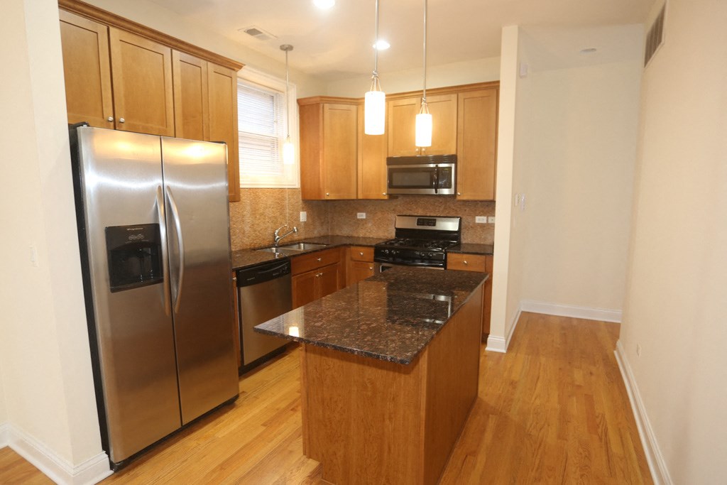 a kitchen with stainless steel appliances and wooden cabinets