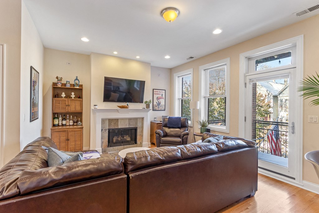 the living room has a fireplace and a leather couch