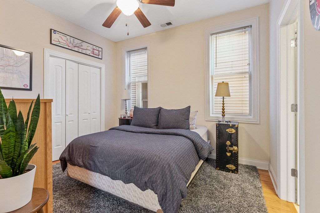 a bedroom with a bed and a ceiling fan