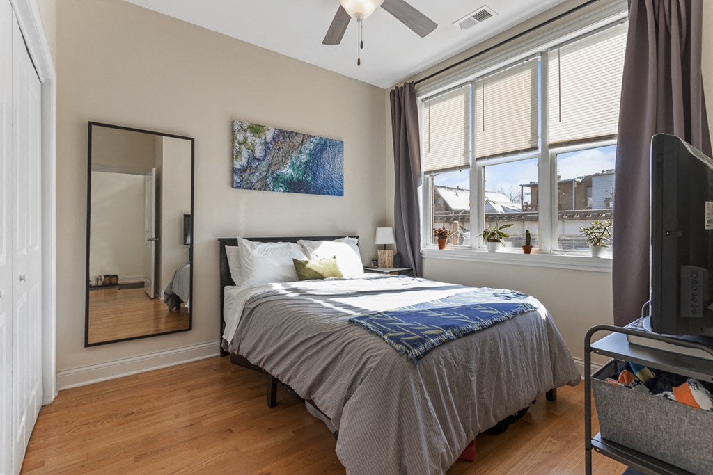 a bedroom with a bed and two windows