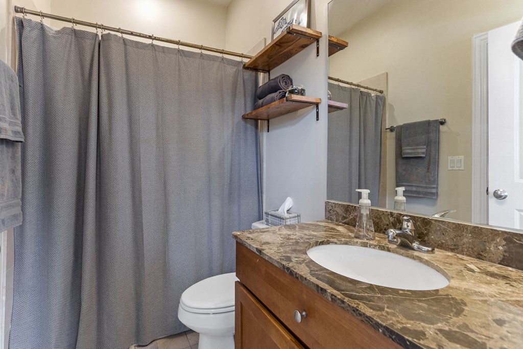 a bathroom with a shower and a sink and a toilet