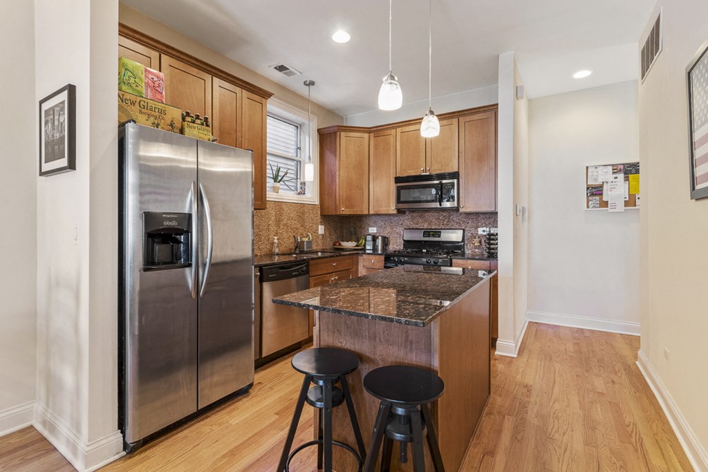an updated kitchen with stainless steel appliances and granite counter tops