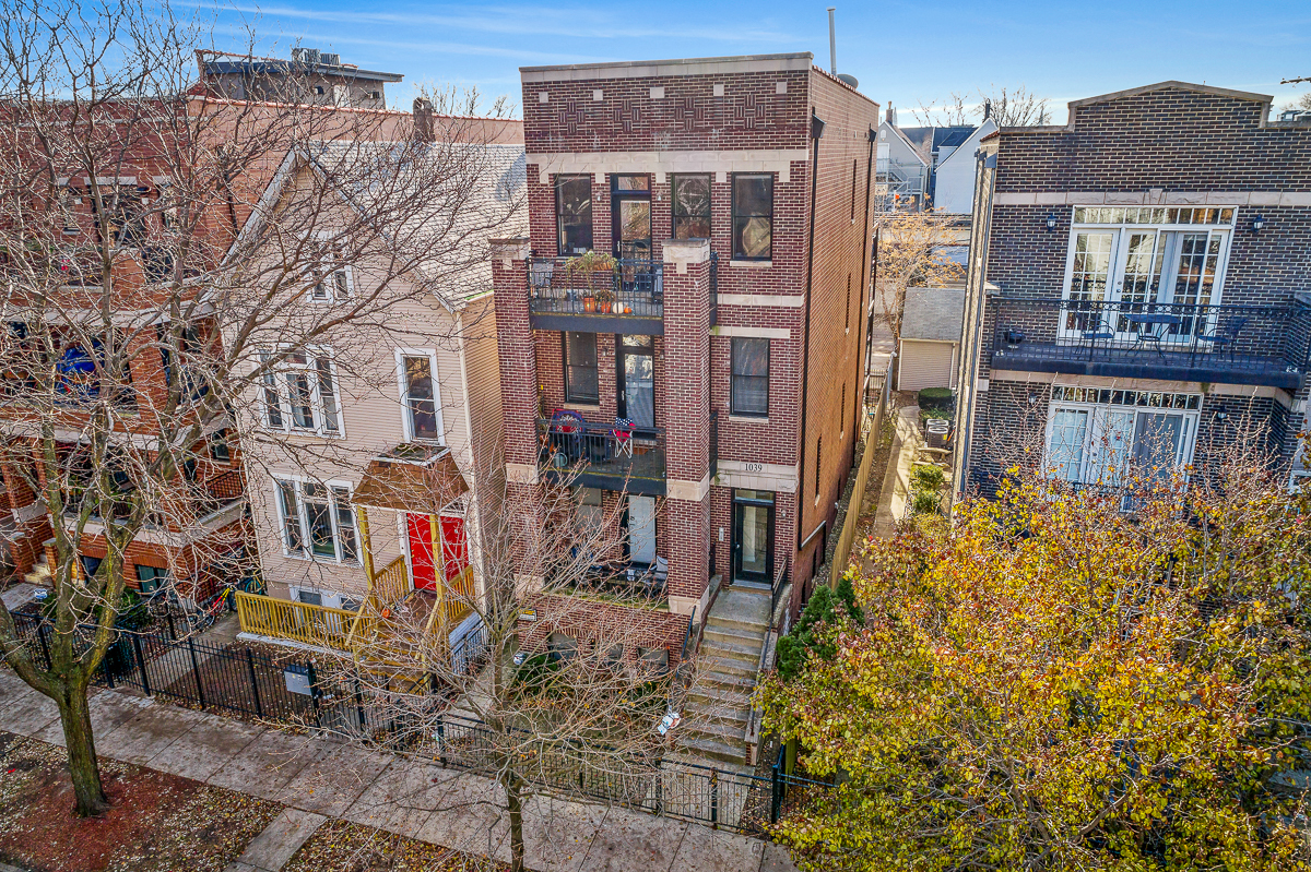 an aerial view of a brick apartment building with stairs and trees