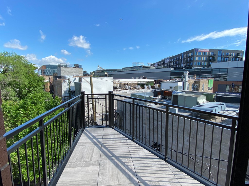 a balcony with a view of a city and a blue sky