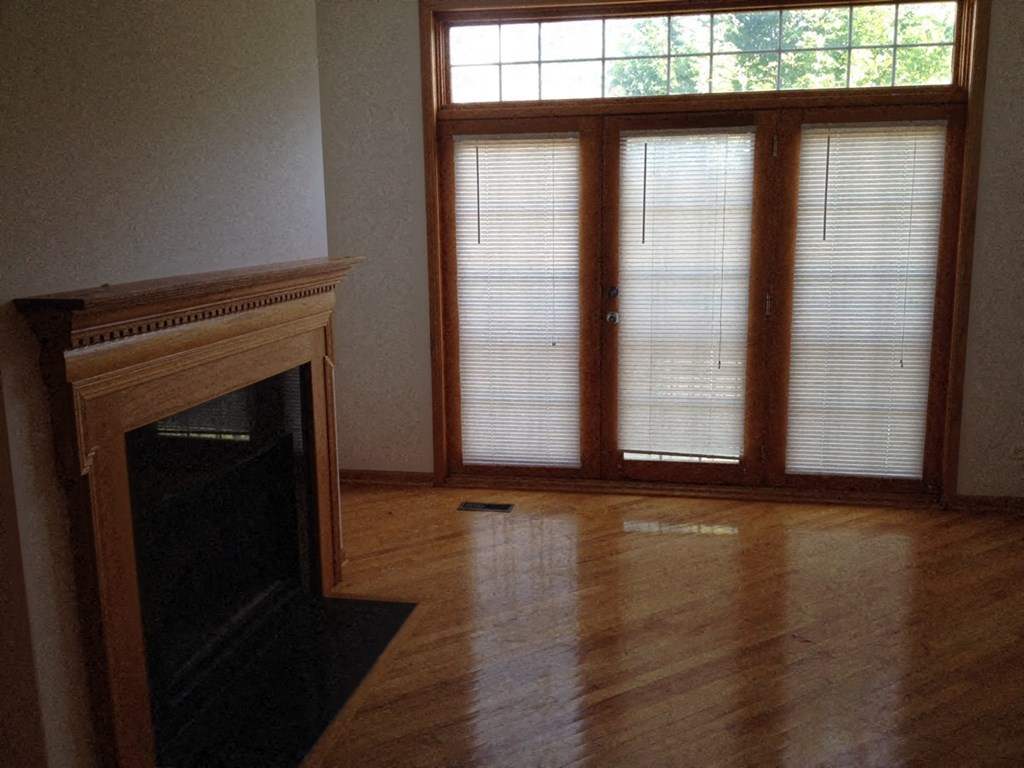 a living room with a fireplace and large windows