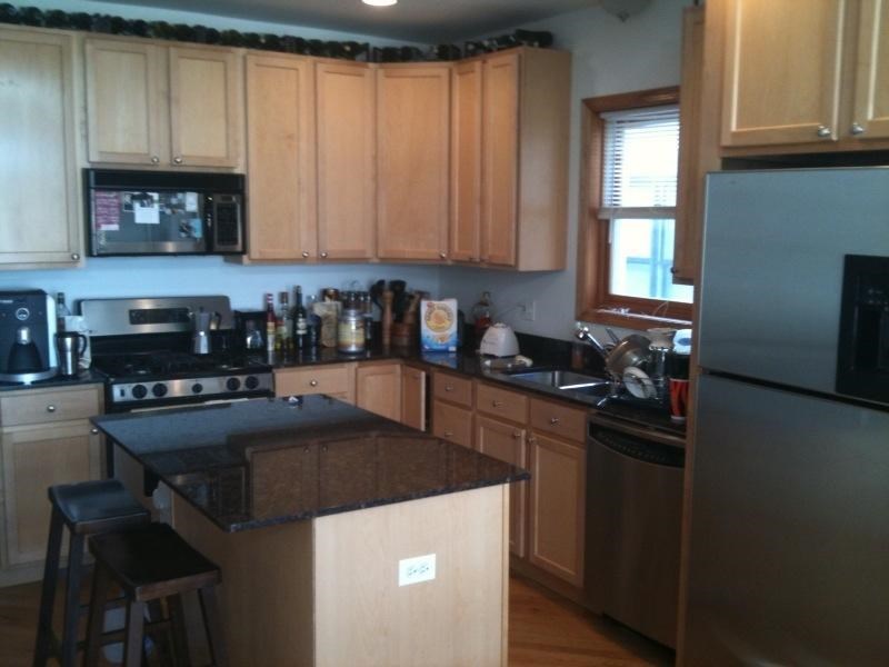 a kitchen with wooden cabinets and a black counter top