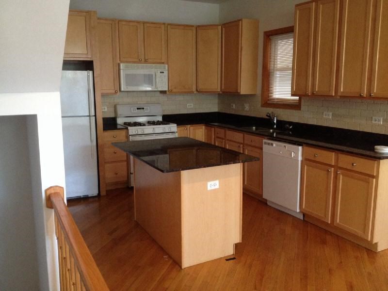 a kitchen with wooden cabinets and a stove and a refrigerator