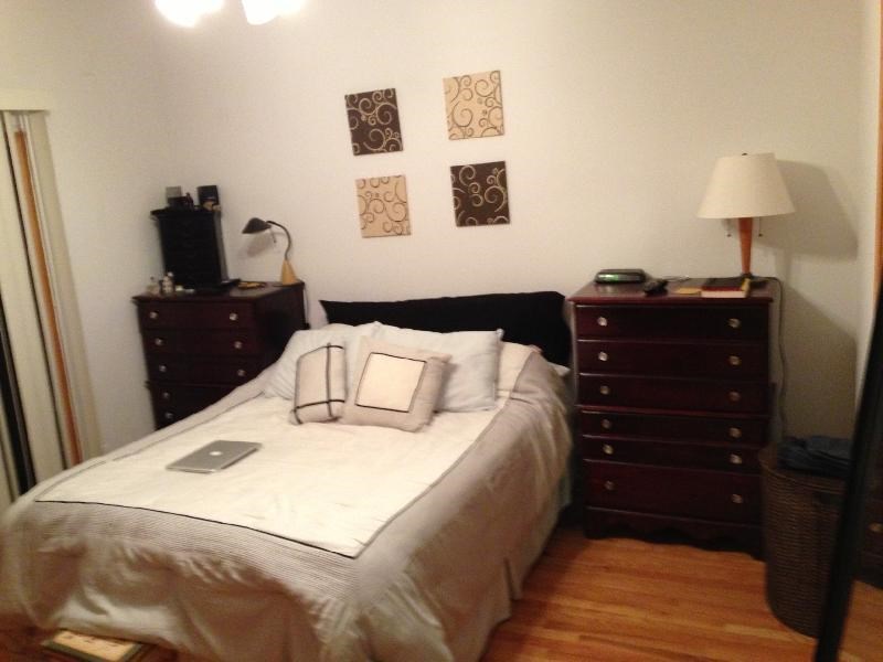 a bedroom with a bed with a laptop on it