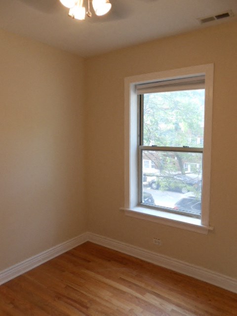 a small room with a window and a wooden floor