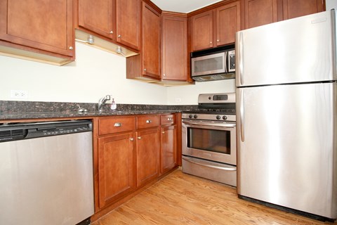 a kitchen with stainless steel appliances and wooden cabinets