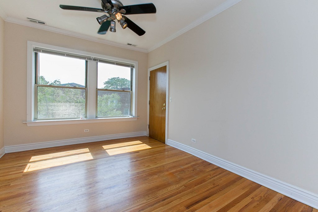 an empty room with wooden floors and a ceiling fan