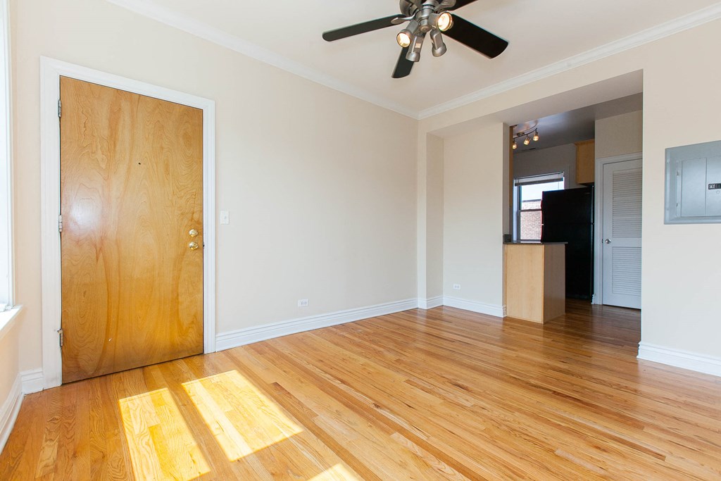 an empty living room with wood floors and a wooden closet