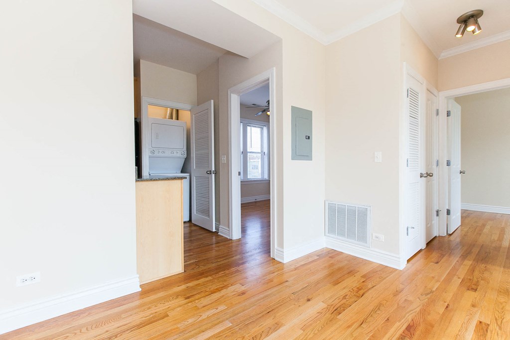 a renovated living room and kitchen with wood floors and white walls