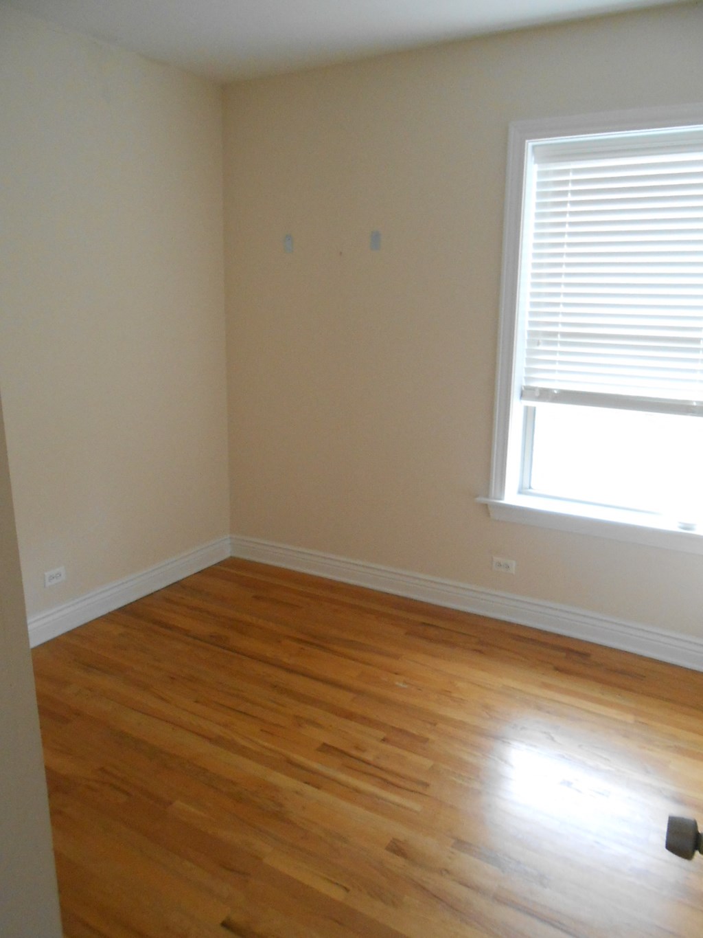 an empty room with wooden floors and a window