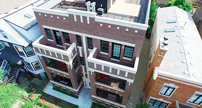 an aerial view of a brick apartment building with balconies