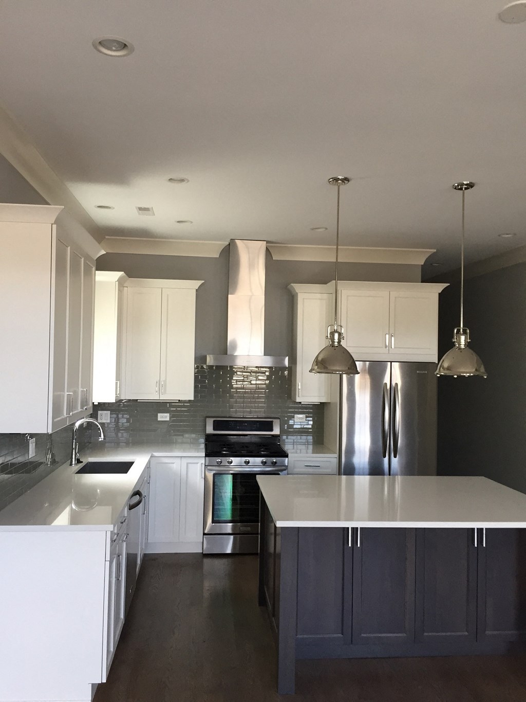 a renovated kitchen with white cabinets and stainless steel appliances