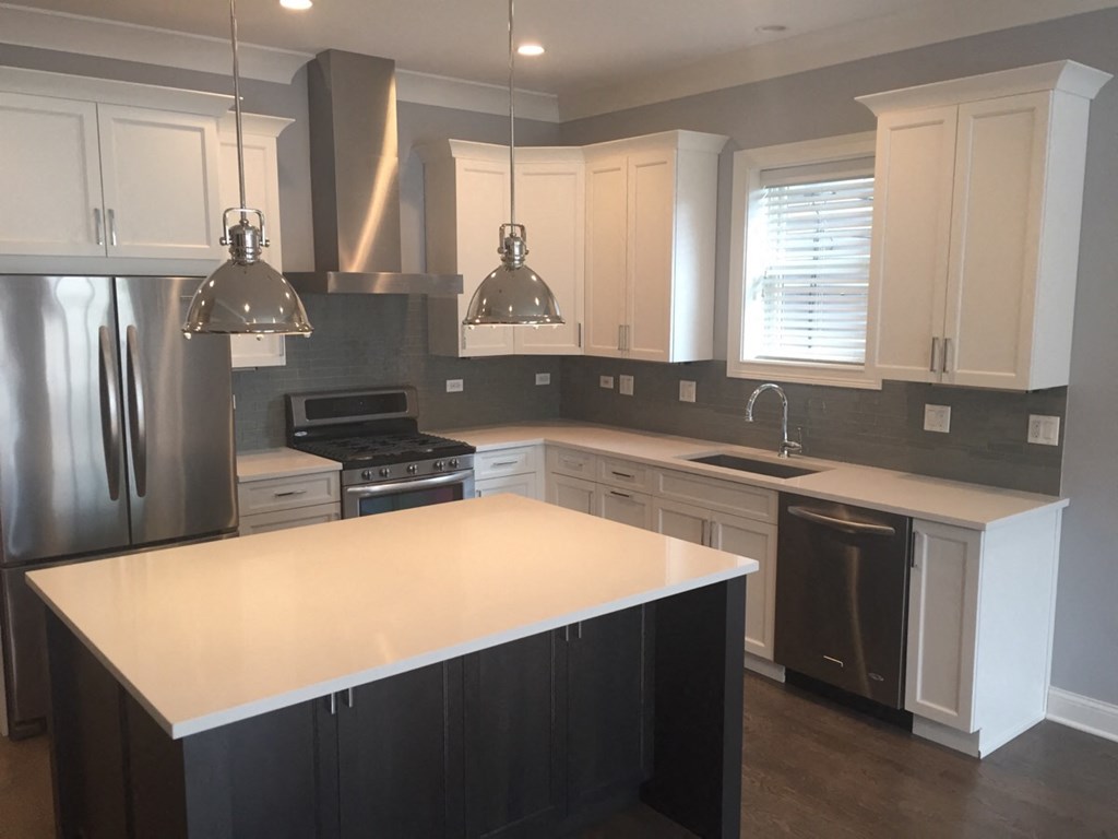 a recent kitchen remodel with white cabinets and stainless steel appliances