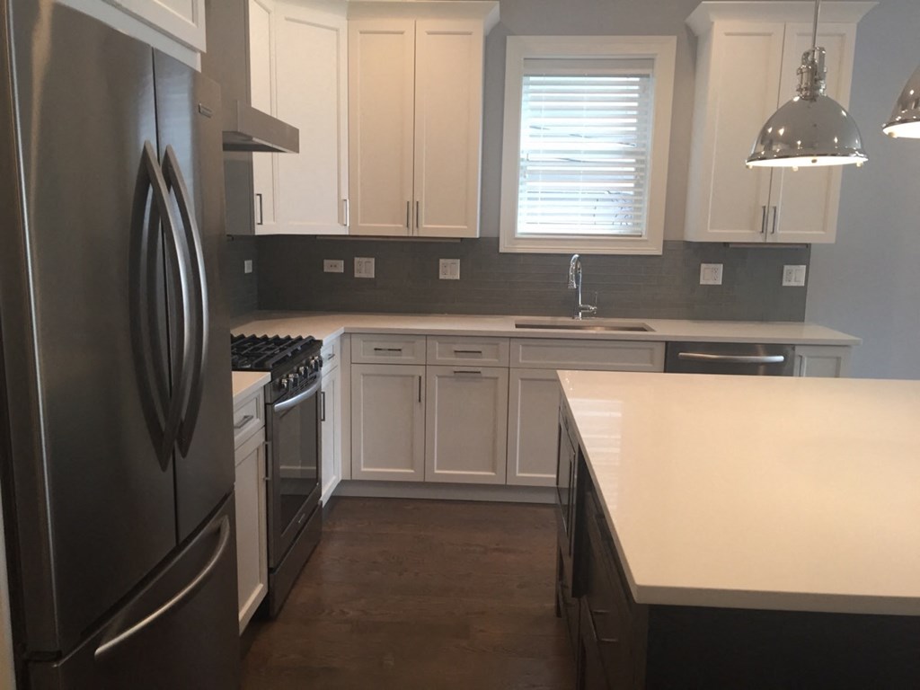 a kitchen with white cabinets and stainless steel appliances