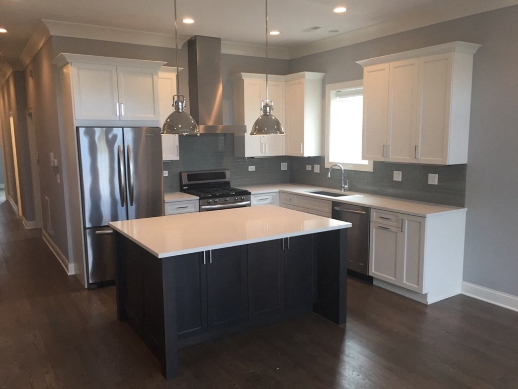 a recent kitchen remodel with white cabinets and stainless steel appliances