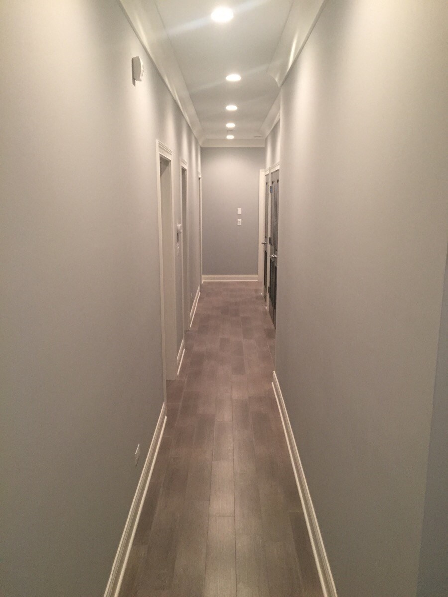 a long hallway with grey walls and a tile floor