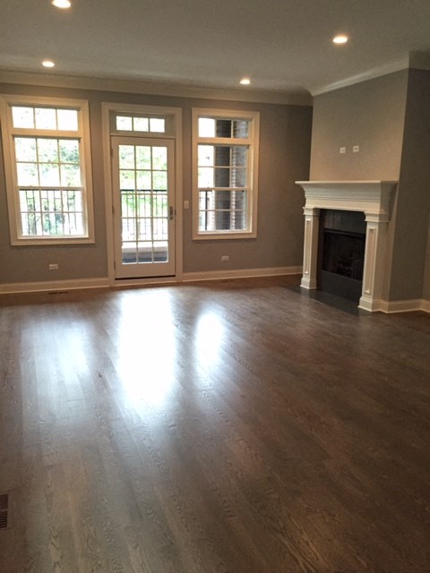 an empty living room with a fireplace and a wooden floor