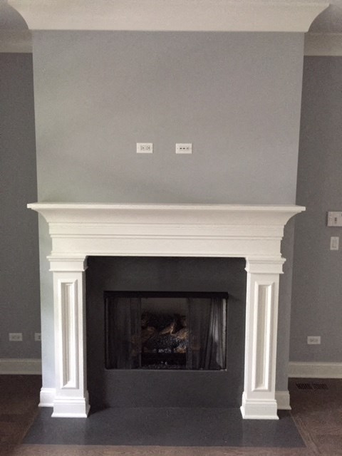 fireplace in the living room with a white mantel and gray walls