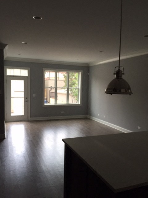 an empty living room with a lamp and a window