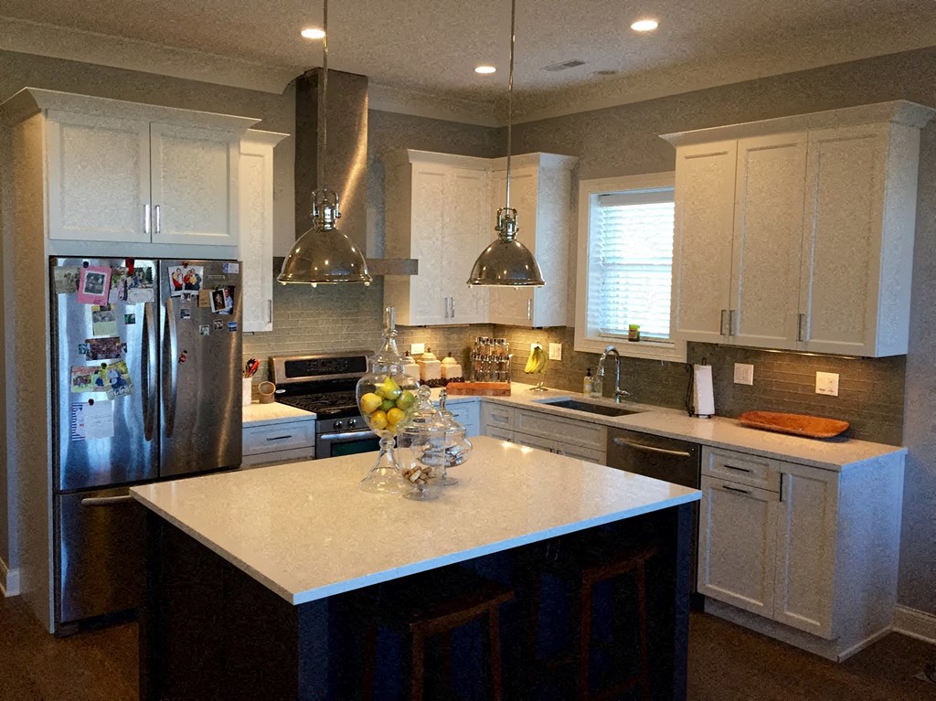 a kitchen with white cabinets and stainless steel appliances