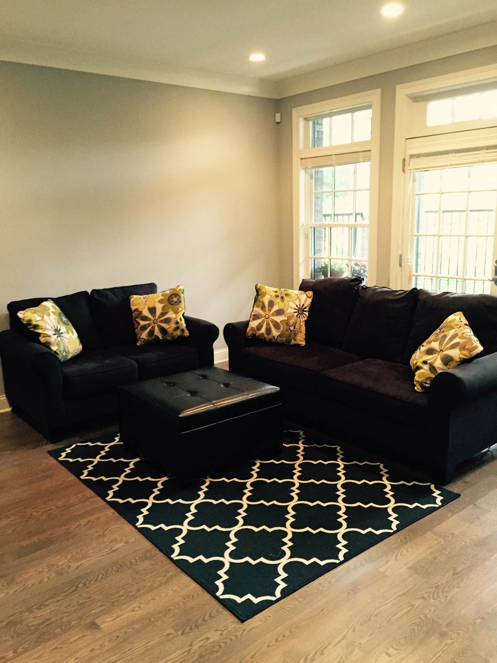 a living room with a black couch and a rug