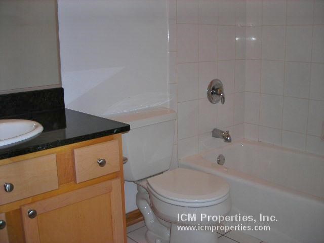 a bathroom with a toilet and a tub and a sink