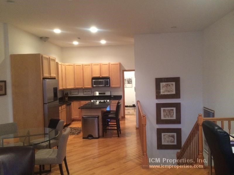 a kitchen and a living room with wooden floors and wooden cabinets