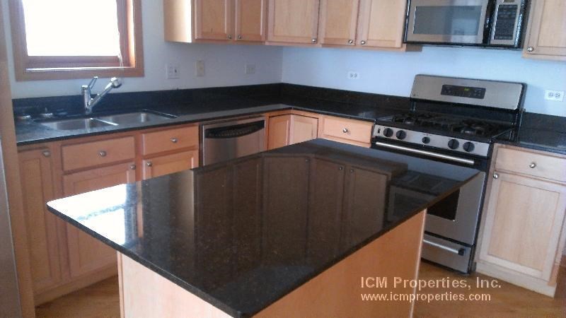 a kitchen with a black counter top and a stove