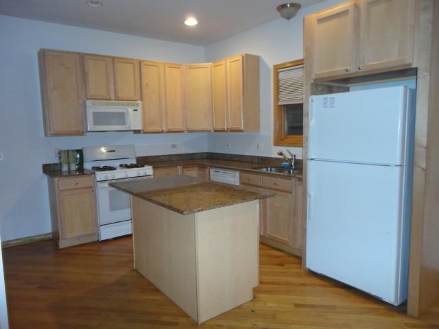 a kitchen with white appliances and wooden cabinets