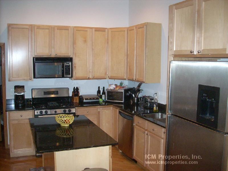 a kitchen with stainless steel appliances and wooden cabinets