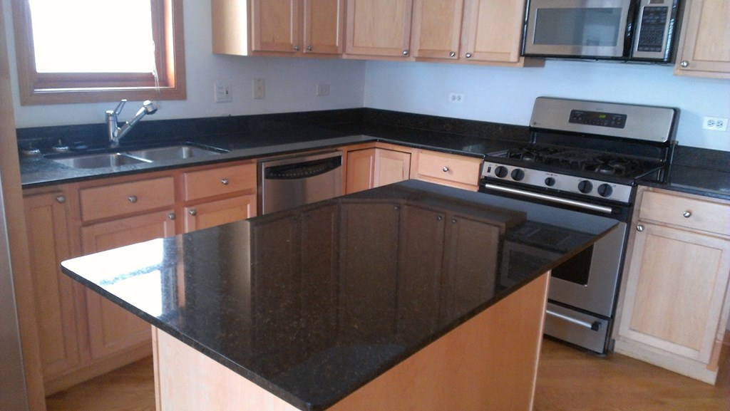 a kitchen with a black counter top and a stove