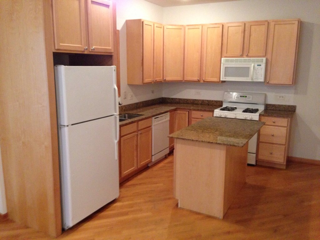 a kitchen with white appliances and wooden cabinets