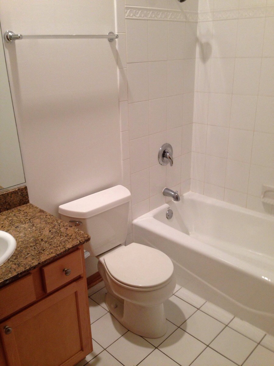 a white bathroom with a toilet and a tub