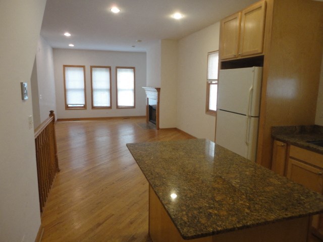 an empty kitchen and living room with a granite counter top