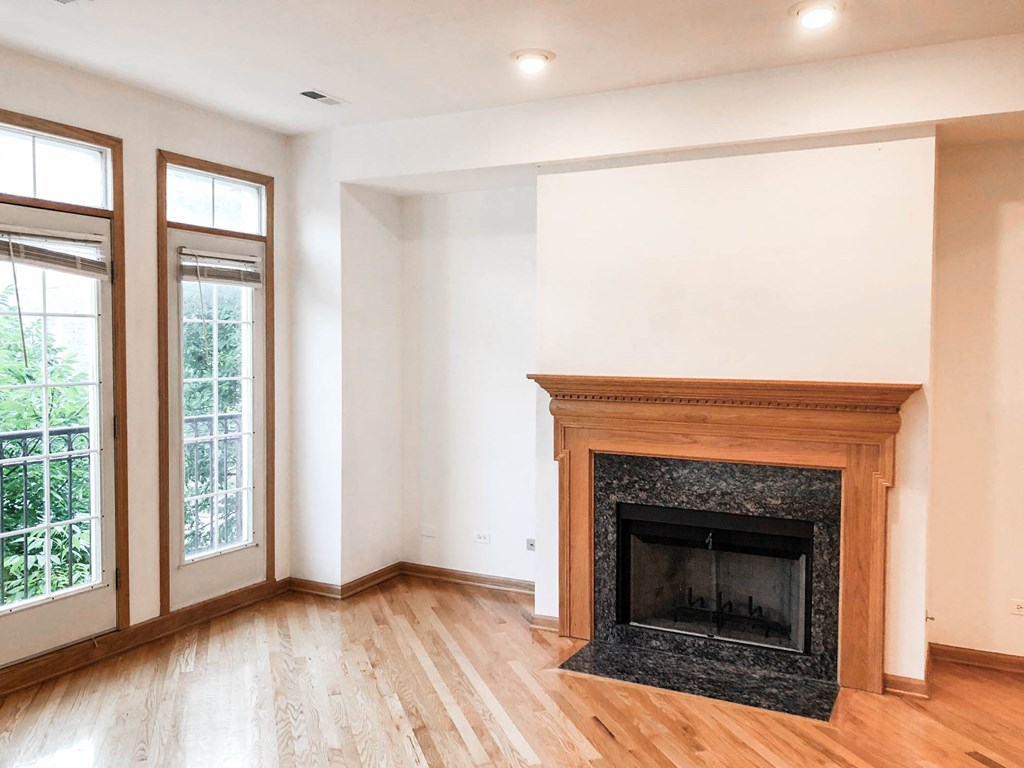 a living room with a fireplace and wooden floors