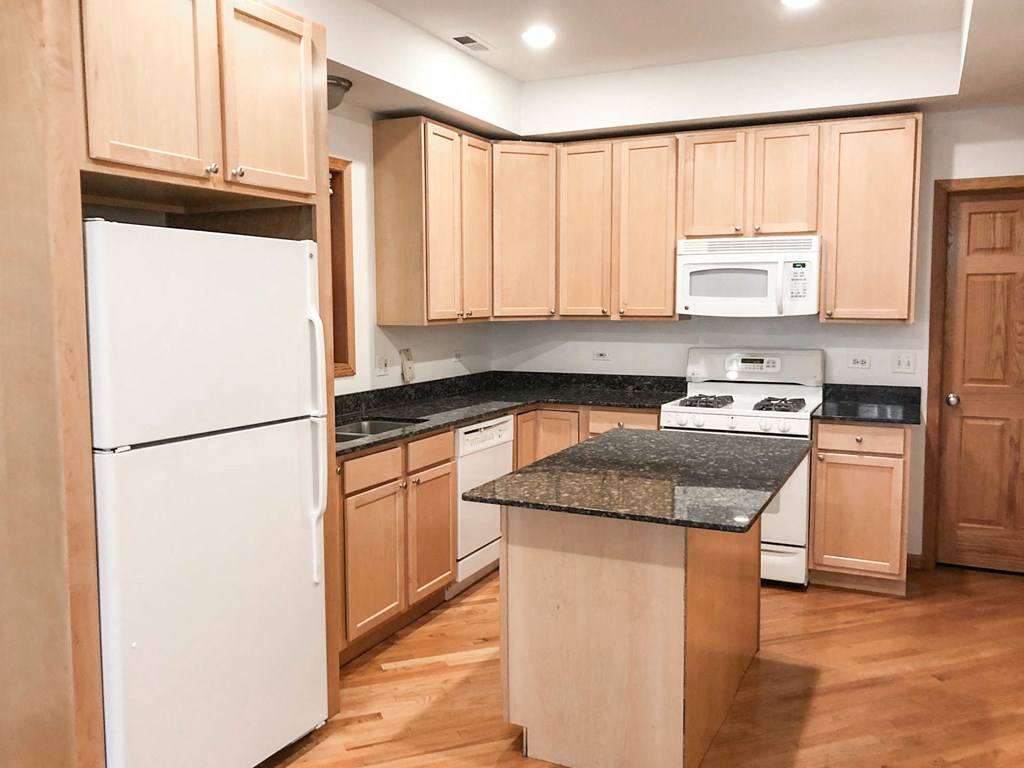 a kitchen with wooden cabinets and a white refrigerator