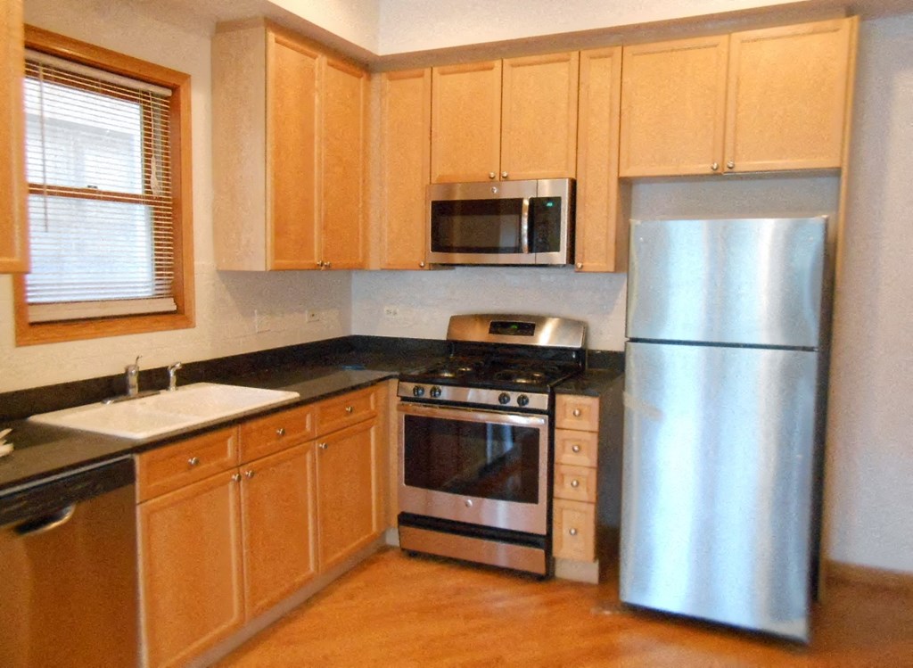 a kitchen with wooden cabinets and stainless steel appliances