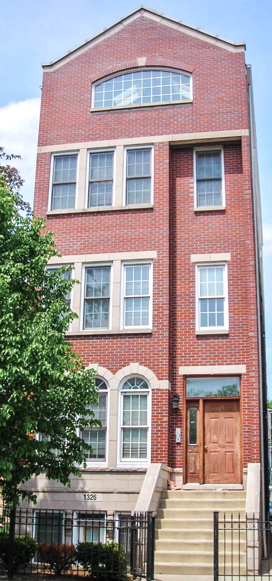 a tall brick building with stairs in front of it