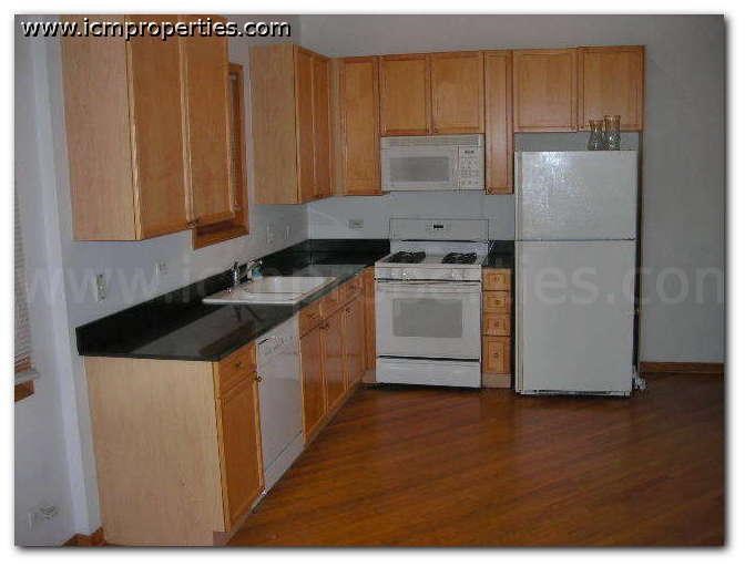 a kitchen with wooden cabinets and white appliances