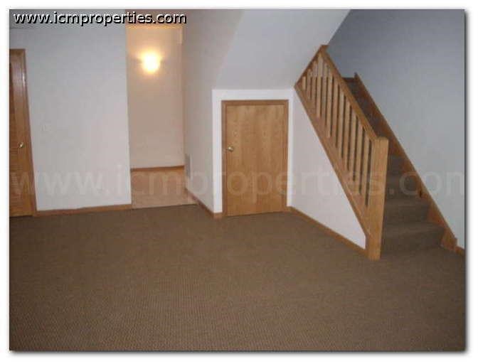 a living room with a staircase and a wooden door