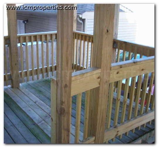 a wooden deck with a house in the background