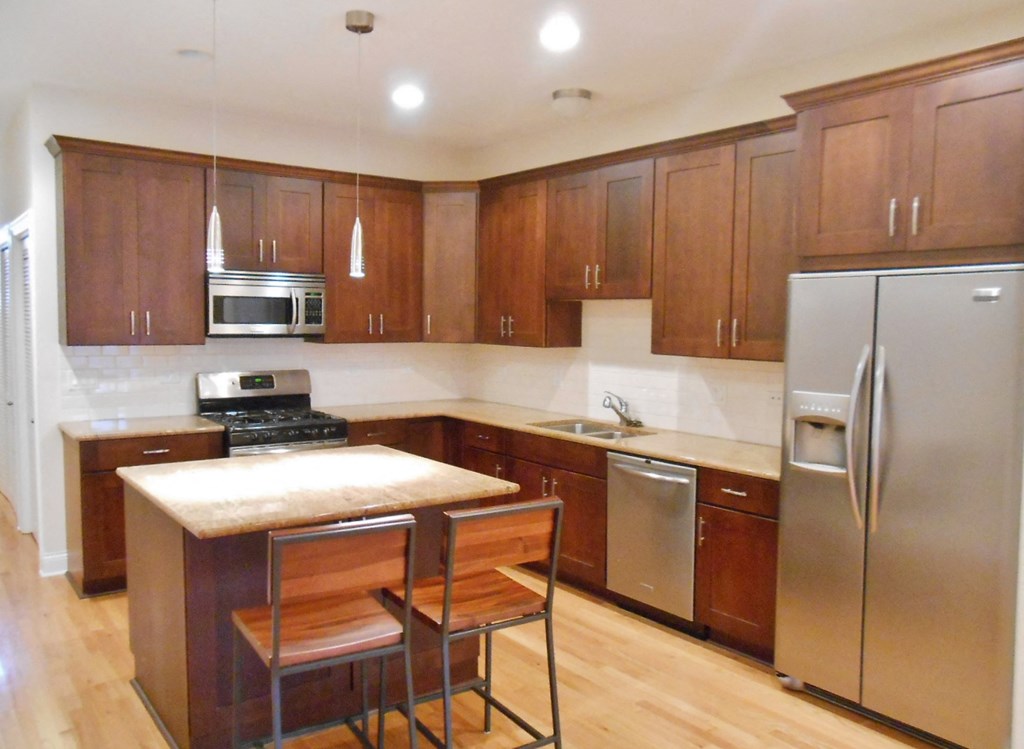 a kitchen with wooden cabinets and stainless steel appliances