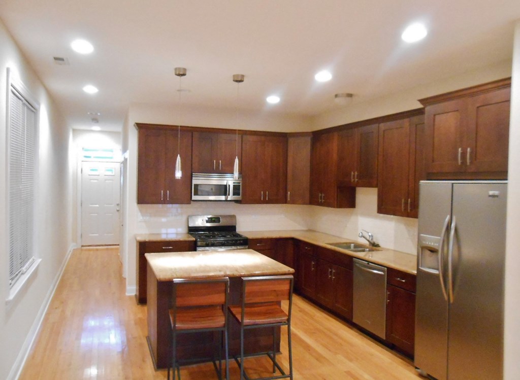 a large kitchen with wooden cabinets and stainless steel appliances